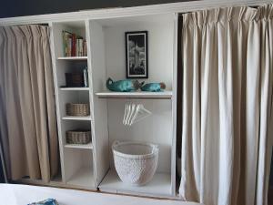 biała półka na książki obok okna z zasłonami w obiekcie Maisonettewohnung Strandburg w mieście Lubmin
