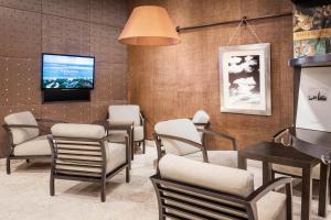 a waiting room with chairs and a flat screen tv at Catalonia El Retiro in Madrid