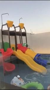 a playground with a slide in a room at شالية الجوهرة in Taif