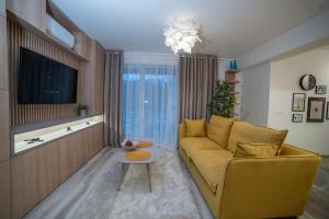 a living room with a yellow couch and a table at Carpe Diem Travel in Timişoara