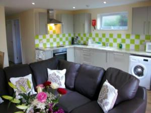 ein Wohnzimmer mit einem Sofa und einer Küche in der Unterkunft ROSE - 2 Bedroom Cottage in Kingsnorth