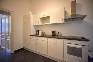 a kitchen with white cabinets and a stove top oven at Self-Check-In & Perfect Metro Connection I in Vienna