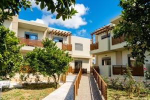 a house with a fence in front of it at Ilyssion Holidays Hotel in Ialyssos