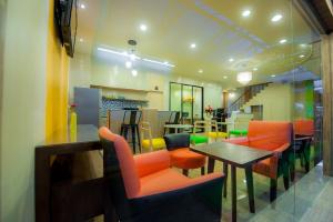 曼谷的住宿－浪漫滿屋賓館，一间餐厅,房间内设有橙色椅子和桌子