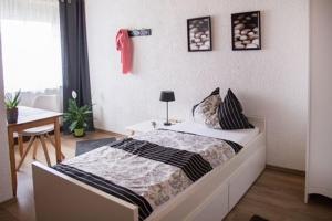 a bedroom with a bed and a table and a desk at Hotel zur Klause in Saarbrücken