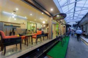 a restaurant with tables and chairs in a building at Full House in Bangkok