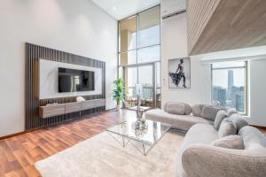 a living room with a couch and a tv at Ultra Luxury JBR Duplex Penthouse - Beach Resorts Neighbourhood in Dubai
