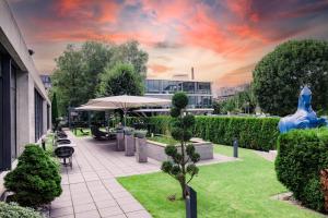 卡爾斯魯厄的住宿－德布勞爾雷特酒店，一个带桌椅和遮阳伞的庭院