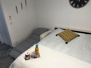 sypialnia z łóżkiem z zegarem na ścianie w obiekcie Chez Julien & Ornella w mieście Saint-Laurent-du-Var