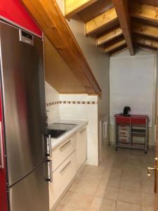 a kitchen with a stainless steel refrigerator and white cabinets at Agarimo das Burgas in Ourense