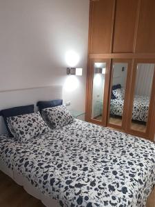 a bedroom with a bed with a black and white comforter at Agarimo das Burgas in Ourense