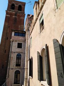 un antiguo edificio con una torre de reloj en una ciudad en San Marco2 Apartment en Venecia