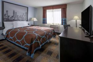 a hotel room with a bed and a flat screen tv at Super 8 by Wyndham Villa Rica in Villa Rica