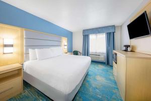 una camera d'albergo con un grande letto e una TV di Days Inn by Wyndham Springville a Springville