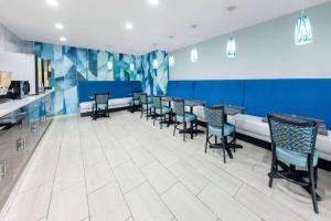 d'une salle à manger avec des tables et des chaises et des murs bleus. dans l'établissement Days Inn by Wyndham Springville, à Springville