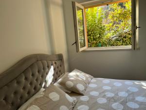 een slaapkamer met een bed met een raam erin bij Villa Nogara in Menaggio
