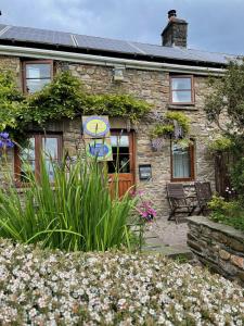 a stone house with a garden in front of it at Tunnel Cottages at Blaen-nant-y-Groes Farm in Aberdare