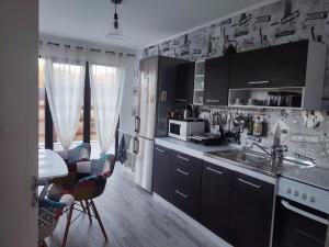 a kitchen with black cabinets and a sink and a table at Cabana La Cassian in Vulcan