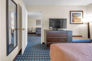 a hotel room with a bed and a flat screen tv at Wingate by Wyndham Schaumburg in Schaumburg