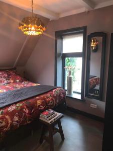 1 dormitorio con cama, ventana y mesa en Bed and Breakfast Waddendroom en Lioessens