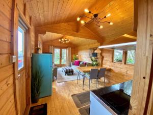 uma cozinha e sala de estar de um chalé de madeira em Yealm Cabin Self Catering Log Cabin in Devon with Hot Tub em Plymouth