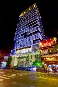 um edifício alto com luzes acesas à noite em Poseidon Nha Trang em Nha Trang