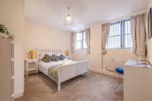 a bedroom with a bed and a desk and windows at Hidden Gem With Windsor Castle Views & Parking in Windsor