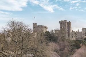 a castle on a hill with trees in front of it at Hidden Gem With Windsor Castle Views & Parking in Windsor