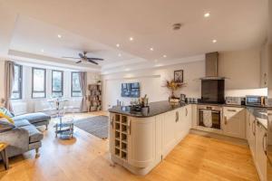 a large kitchen with a large island in a living room at Hidden Gem With Windsor Castle Views & Parking in Windsor