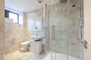 a bathroom with a shower and a toilet and a sink at Hidden Gem With Windsor Castle Views & Parking in Windsor +17 photos