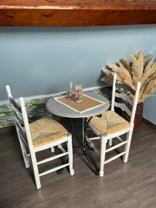 un tavolo con due sedie e un tavolo con tavolo e sedie di LES FLORALIES a Froberville