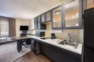 a kitchen with a sink and a desk at Sonesta Simply Suites Oklahoma City Airport in Oklahoma City