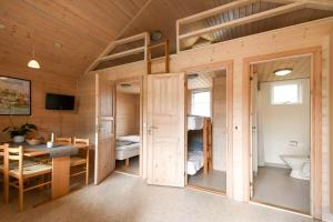 - une chambre avec des lits superposés et une table dans l'établissement First Camp Skovlund Camping & Cottages, à Båring
