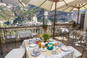 ein Restaurant mit Tischen und Stühlen und Bergblick in der Unterkunft Villa Palumbo in Positano