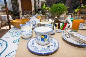 Villa Palumbo في بوسيتانو: طاولة عليها أكواب وصحون زرقاء وبيضاء