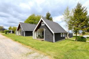 ein kleines Haus am Straßenrand in der Unterkunft First Camp Skovlund Camping & Cottages in Båring