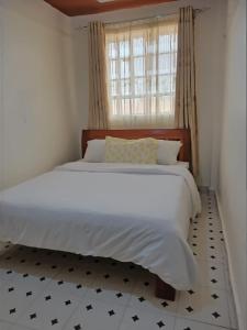 sypialnia z dużym białym łóżkiem i oknem w obiekcie Zuri Stays Machakos Town w mieście Machakos
