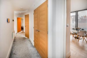 a hallway with wooden doors and a dining room at Modern & spacious 2-bed flat with secure parking in Reading