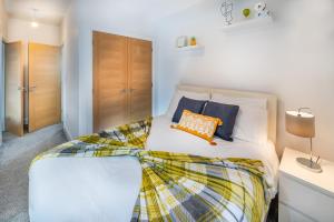 a bedroom with a large white bed with orange pillows at Modern & spacious 2-bed flat with secure parking in Reading