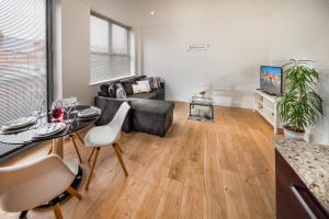 a living room with a couch and a table at Modern & spacious 2-bed flat with secure parking in Reading