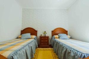 een slaapkamer met 2 bedden en een dressoir. bij Casa Ourense Guxinde in Pereira