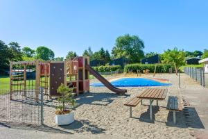 a playground with a slide and a picnic table at First Camp Skovlund Camping & Cottages in Båring