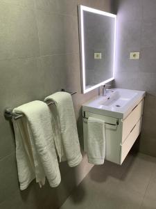 a bathroom with a white sink and towels at Casa Torres in San Bartolomé de Tirajana +31 photos