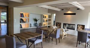 a dining room with tables and chairs and a fireplace at Boutique Hôtel La Villa MONTESQUIEU in Laudun
