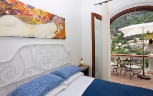 Schlafzimmer mit einem Bett und Blick auf einen Balkon in der Unterkunft Villa Palumbo in Positano