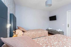 a bedroom with two beds and a flat screen tv at Sunnyland Teresitas 2 in San Andrés