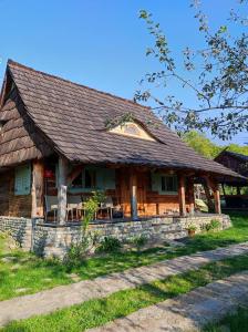 a wooden house with a roof on a field at Jabłoniowy Sad Kalwaria Pacławska in Kalwaria Pacławska