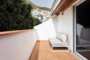 Sofá blanco sentado en un balcón con vistas en Sunny island atico las teresitas 4 en San Andrés