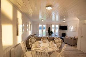 sala de estar con mesa, sillas y sofá en Stunning lodge on the lake en South Cerney