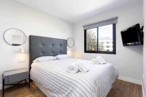 a bedroom with a bed with two towels on it at Sunnyland Lago Martianez 3 in Puerto de la Cruz +18 photos